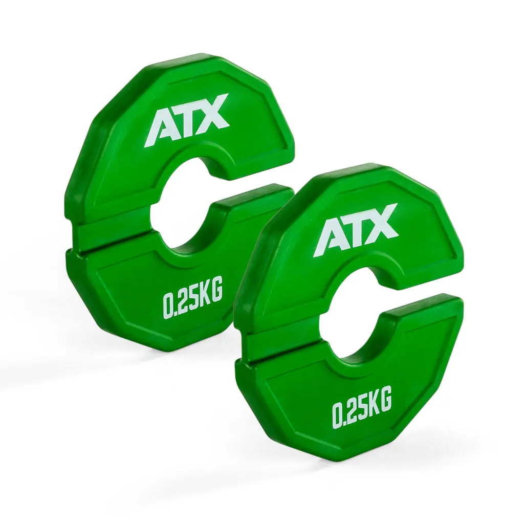 Two green ATX weight plates, each labeled 0.25KG, feature a unique geometric shape and an open segment for easy barbell attachment. Ideal for precision training—perfect if you’re following a Fractional Plate Buying Guide.