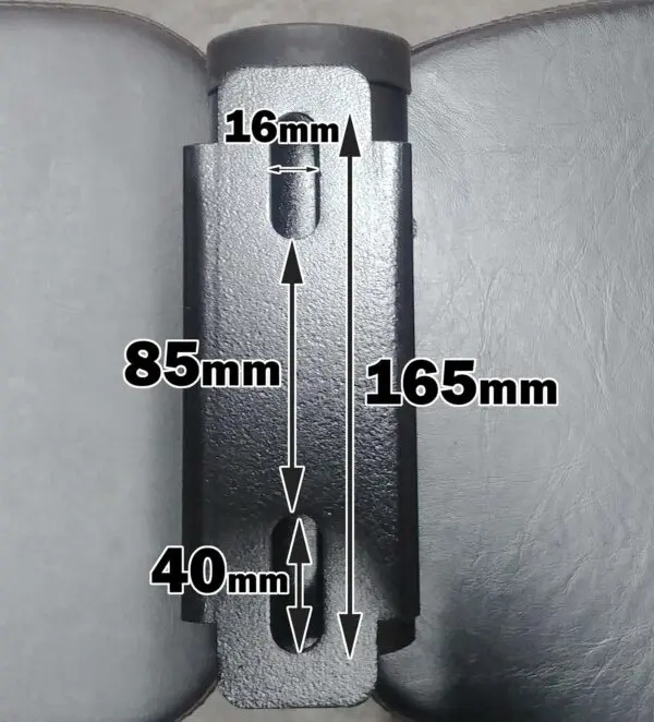 The ATX® Barbell Storage, a metal bracket with a vertical design, features dimensions of 165mm in height, 85mm inner width, and top and bottom openings of 16mm and 40mm wide respectively. It is displayed against a dark surface.
