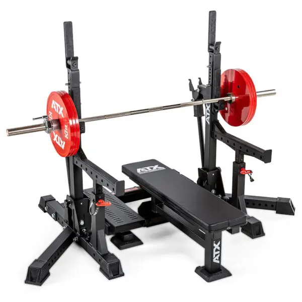 A weightlifting setup featuring the ATX® Competition Combo Rack with a black bench and adjustable barbell holder. A barbell with red plates rests on the rack, all branded with ATX logos.