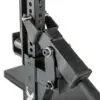 Close-up of the ATX® Competition Combo Rack, a black adjustable weightlifting rack with numbered height settings and secure locking mechanisms. Its sturdy design features a base and metal pegs for securing the barbell.