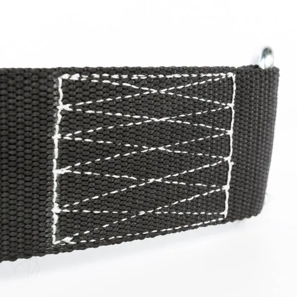 Close-up of the ATX® Nylon Dip Belts black strap with zigzag-patterned white stitching, securely attached to a metal loop on the right, all against a clean white background.