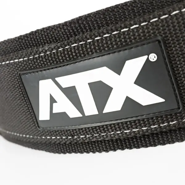 Close-up of the ATX® Nylon Dip Belt, black with white stitching and a rectangular black patch featuring ATX in bold white letters.