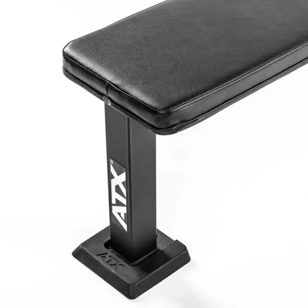 A black ATX® Flat Bench PRO features a cushioned top and a sturdy rectangular metal frame, with the ATX logo on its side, set against a white background.