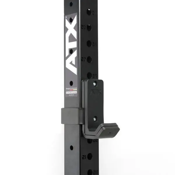 Close-up of a black metal gym rack with ATX vertically on the side. This ATX® J Hooks Compact features adjustable holes numbered 21 to 27 and a J-hook attachment.