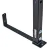 The ATX® Wall Mounted Squat Rack includes a black metal L-shaped support bracket featuring a vertical section with two bolts. Its flat base has mounting holes and is labeled with small text and icons for functionality and clarity.