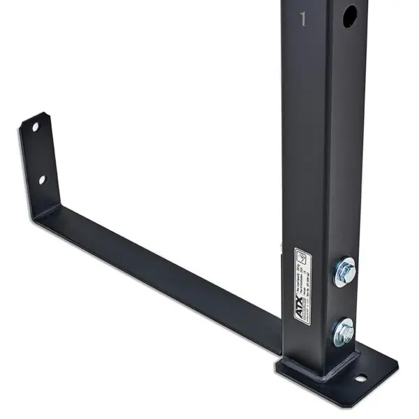 The ATX® Wall Mounted Squat Rack includes a black metal L-shaped support bracket featuring a vertical section with two bolts. Its flat base has mounting holes and is labeled with small text and icons for functionality and clarity.
