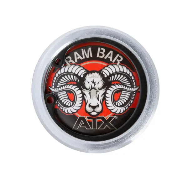 A circular end cap on The Original ATX® Ram Olympic Power Bar showcases a bold rams head logo against a red backdrop, with RAM BAR ATX prominently displayed, all encircled by an elegant metallic silver border.