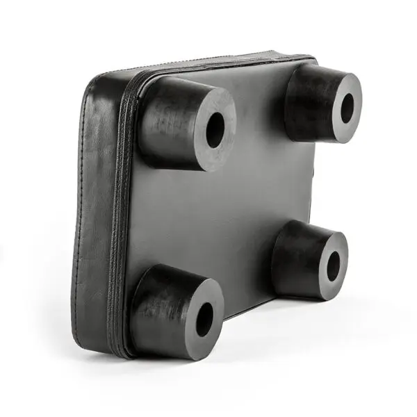 The ATX® Pec Fly Attachment is a black, rectangular leather pad featuring four cylindrical rubber legs at the corners on one edge. It has a smooth texture and is designed to provide support or protection.