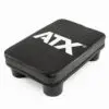 A rectangular black step platform with rounded corners and four short legs has a textured surface and features the ATX® Pec Fly Attachment brand name in prominent white lettering on top.