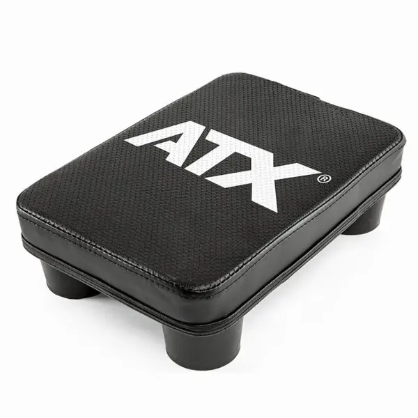 A rectangular black step platform with rounded corners and four short legs has a textured surface and features the ATX® Pec Fly Attachment brand name in prominent white lettering on top.