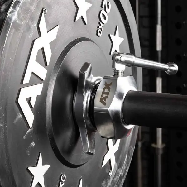 A close-up features a 20 kg weight plate secured by ATX® Competition Powerlifting Collars IPF, with star designs on the plate against a sleek black rack backdrop.