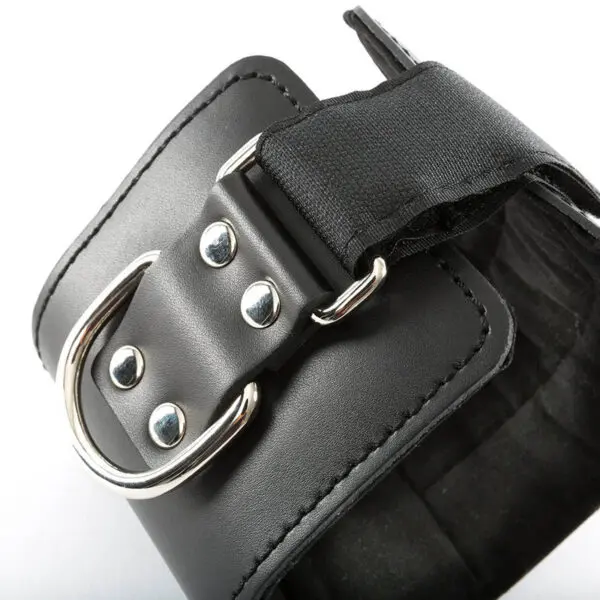 Close-up of the Cable Machine Ankle Cuff in black PU leather, featuring a silver metal buckle and rivets. A black strap threads through the buckle, with visible stitching adding texture and detail.