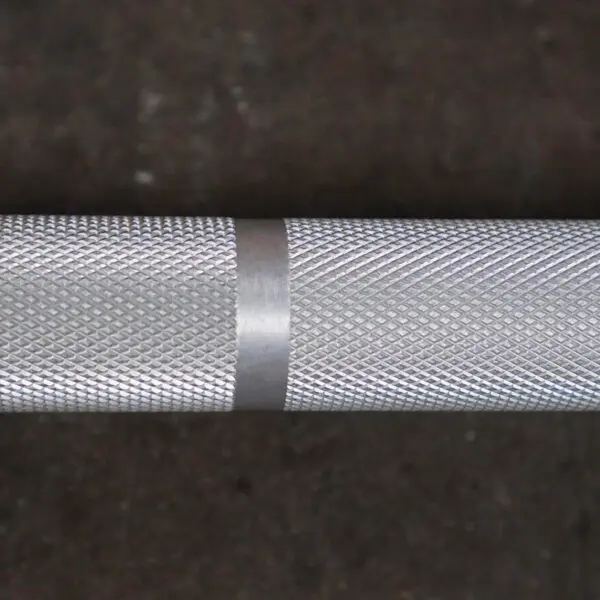 Close-up of the Aluminium 7.5kg Technique Olympic Bar featuring a textured, diamond-patterned grip and a smooth center band, set against a dark background.