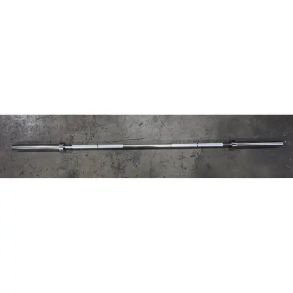 A 7ft Olympic Barbell Thrust Bearings 1000lbs sits on a textured gray surface, featuring a symmetrical design with wider ends for weight addition.