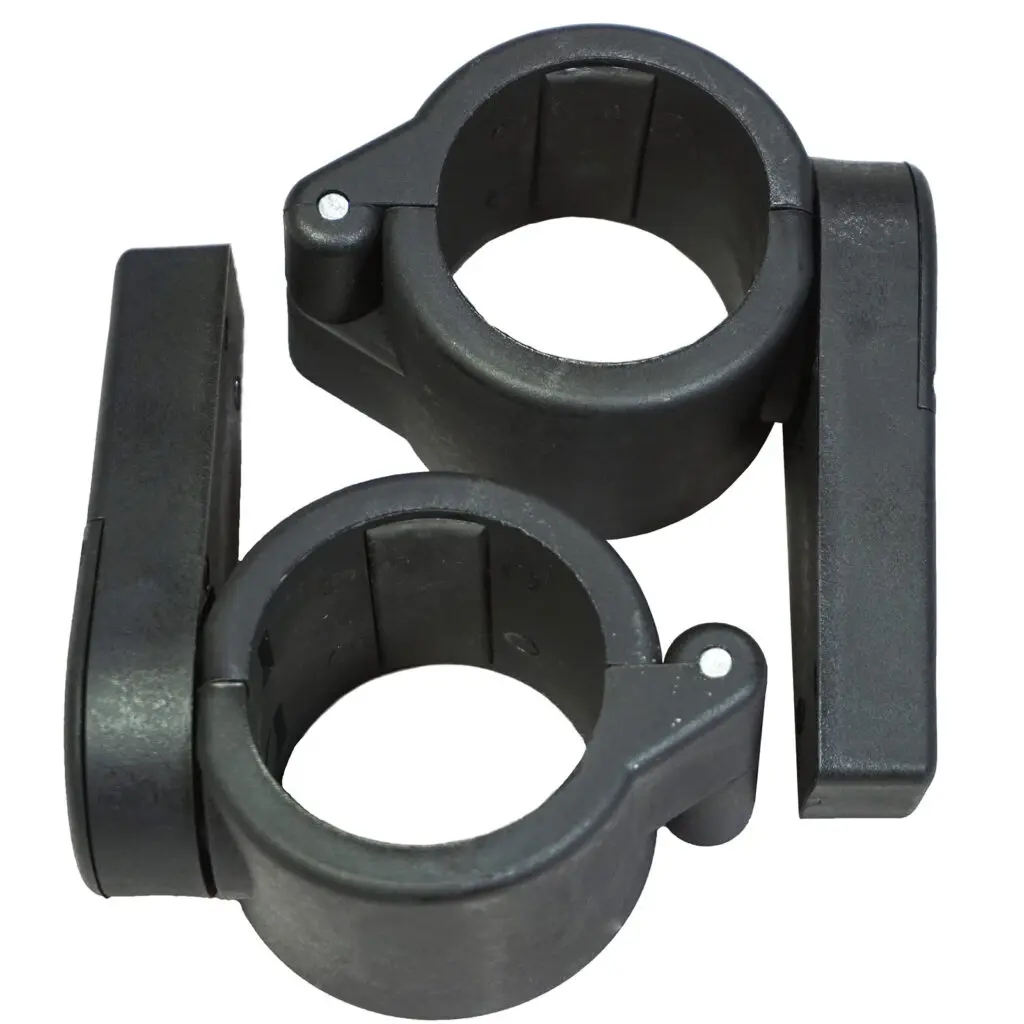 Two Power Maxx Olympic Bar Clamps, black plastic with circular openings, secures pipes or rods. Each clamp has a hinged latch for easy fastening and release. The clamps sit side by side on a white background.