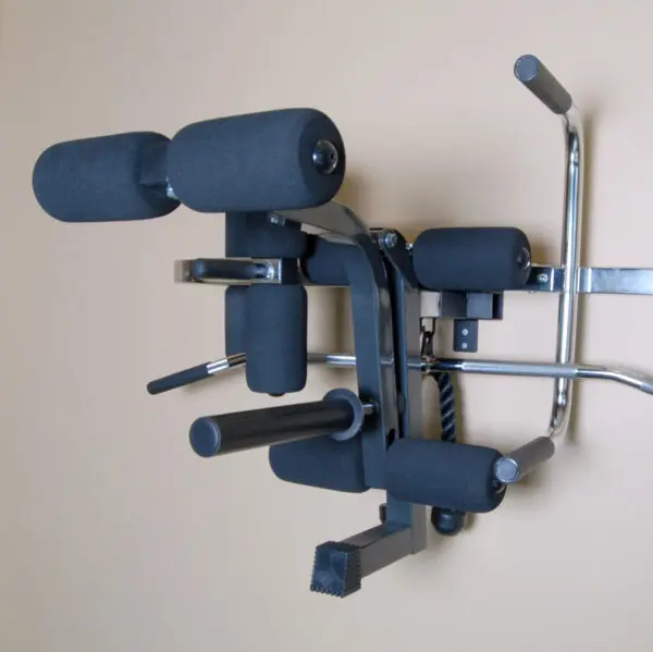 The Ironmaster Ultimate Chin Up Attachment for IM2000 is a versatile wall-mounted gym tool featuring padded supports and metal handles, perfect for strength training exercises like pull-ups, dips, and leg raises against a beige wall background.