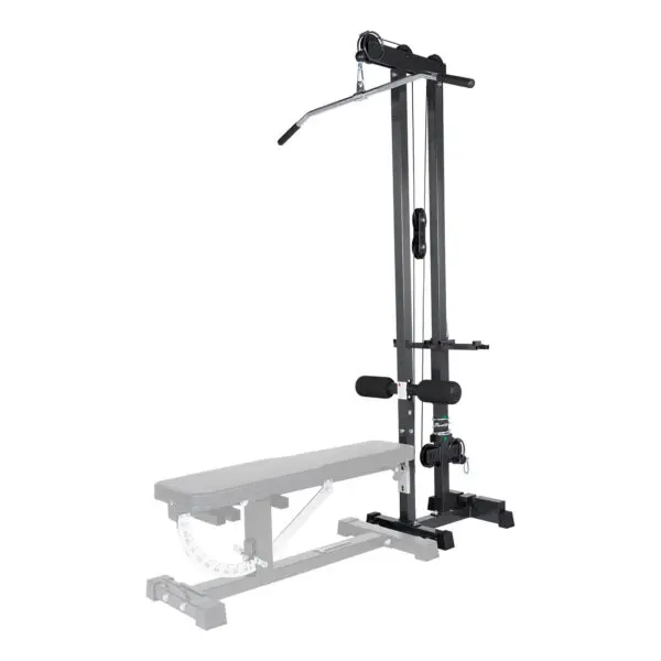 The Ironmaster Cable Tower Attachment V2, black and adjustable, is designed for home gyms. It features a padded seat, stabilizing bar, and a long lat pulldown bar. A weight bench is partially visible in the foreground.