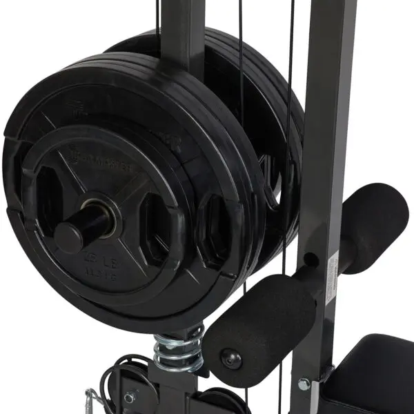 Close-up of the Ironmaster Cable Tower Attachment V2, showcasing multiple black weight plates with a 25 lb mark stacked on a rod. The machine has padded grips and a sleek metal frame.
