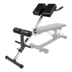The Ironmaster Hyper Core Attachment is an adjustable exercise bench with black cushioned supports on a metal frame and a foam-padded leg support bar, designed for back workouts. The bench section is partially visible in the background.