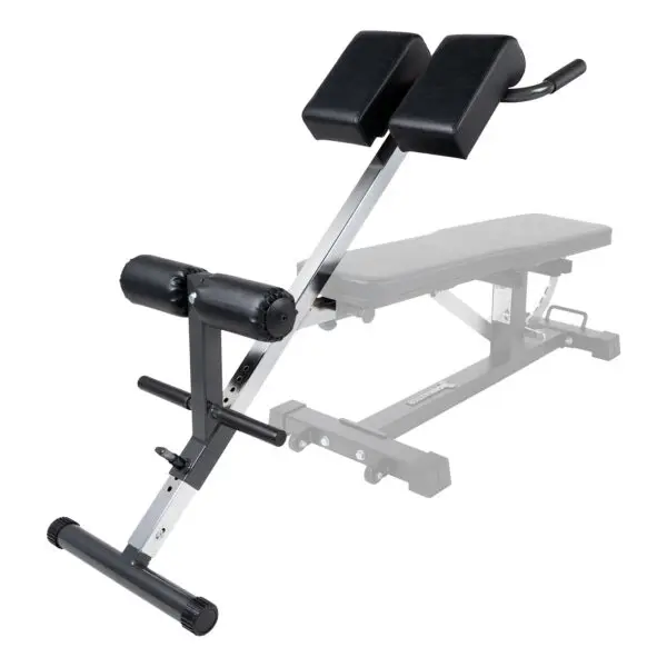 The Ironmaster Hyper Core Attachment is an adjustable exercise bench with black cushioned supports on a metal frame and a foam-padded leg support bar, designed for back workouts. The bench section is partially visible in the background.
