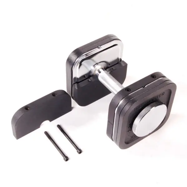 An Ironmaster Heavy Handle Kit adjustable dumbbell, sleek in black and silver with a central dial, rests on a white surface. Nearby are two black connector pieces and rods for adjusting or assembling the dumbbell.