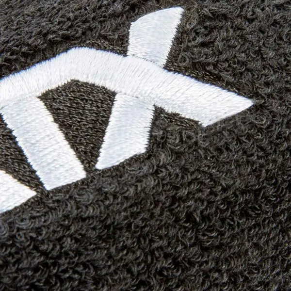 Close-up of black textured fabric on the Kettlebell Wrist Guard with white embroidered letters and a thick, looped surface pattern.