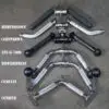 A variety of gym cable attachments, including tricep ropes, a V-bar, straight bars, and multi-grip handles like the Wide Press Down Bar with chrome and black finishes, are displayed on the floor with labels next to each.