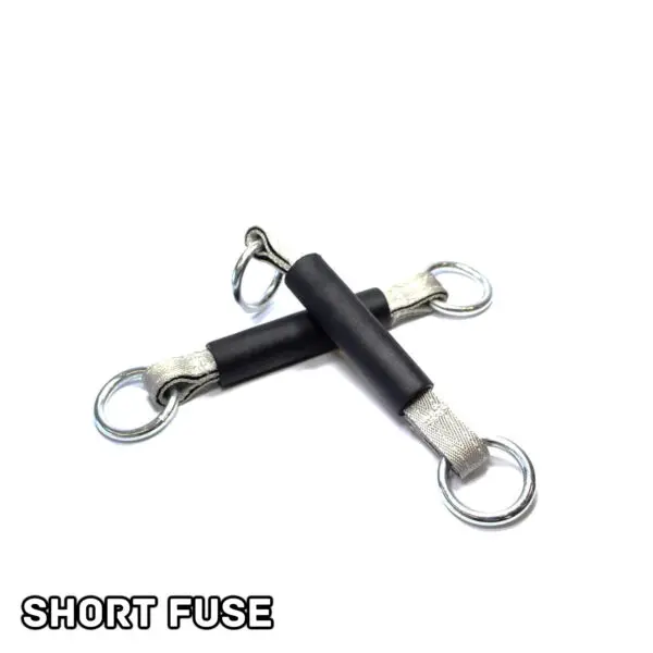 Two black and silver Spud Inc Dynamite Stick resistance bands with metal rings at each end are crossed on a white background. SHORT FUSE is printed in bold black letters in the bottom left corner.