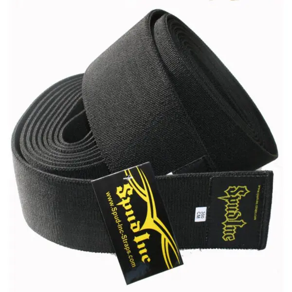 A rolled black lifting strap features a Spud Inc label in yellow. This durable weightlifting support is named Spud Inc Hooker Straps.