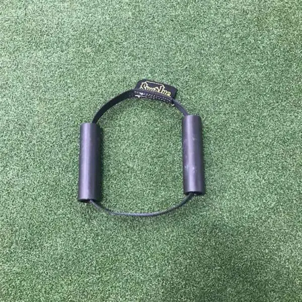 A Spud Inc Hooker Straps workout handle with a rope lies on a green carpet.
