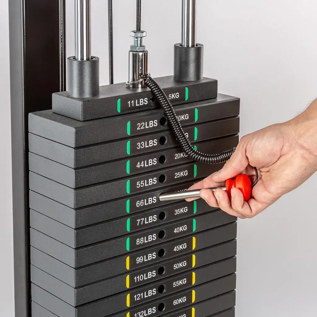 Man slipping a weight stack pin into weight stack. 