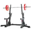 The ATX® Competition Combo Rack features a barbell loaded with red weight plates. This black rack includes adjustable height settings and safety catches, ideal for weightlifting and strength training exercises.