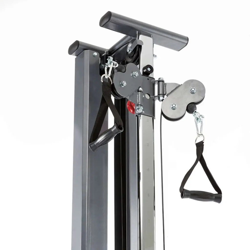 A close-up of a cable trainer on a home gym machine showcases black straps, metal chains, and adjustable handles. This setup, akin to the wall-mounted cable machine design, is perfect for various strength training exercises.