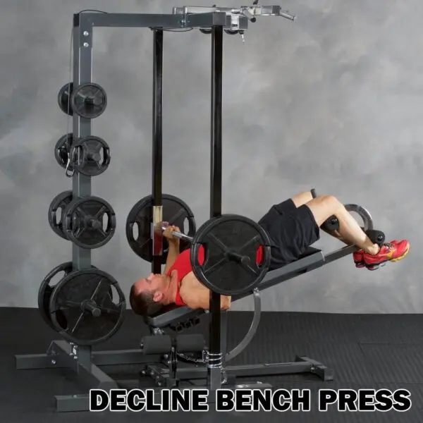 A person in gym attire uses the Ironmaster IM2000 Self-Spotting Smith Machine for a decline bench press, with the bench angled downward and weight plates stacked on both sides.