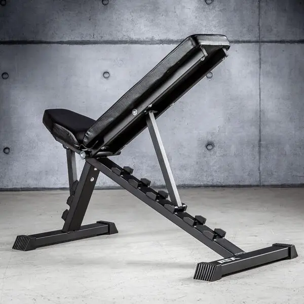 The discontinued ATX® Multi Bench 102 features a black padded seat and backrest, set at an incline against a concrete wall in a gym setting.