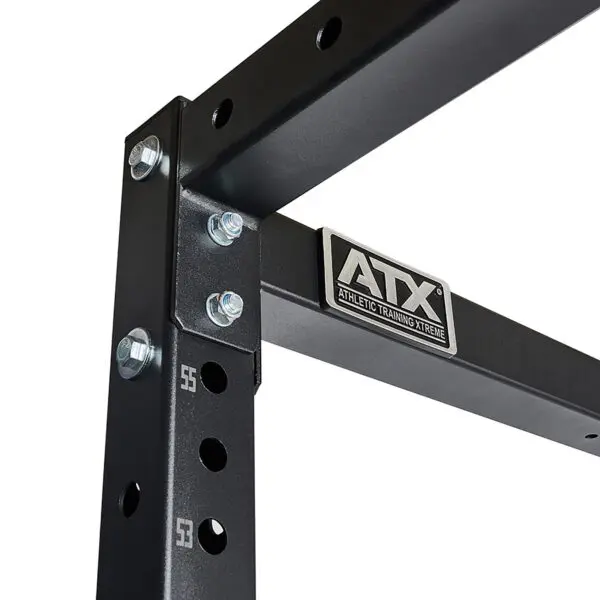 Close-up of a black metal gym rack labeled ATX® Power Rack 755 Short Distance, featuring multiple bolt holes for adjustability and sturdy metal bolts securing the structure.