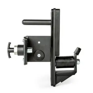 A black mechanical device with a cylindrical handle, a knob, and a roller. It features a metal plate with bolts and various geometric components. The device is positioned against a white background.