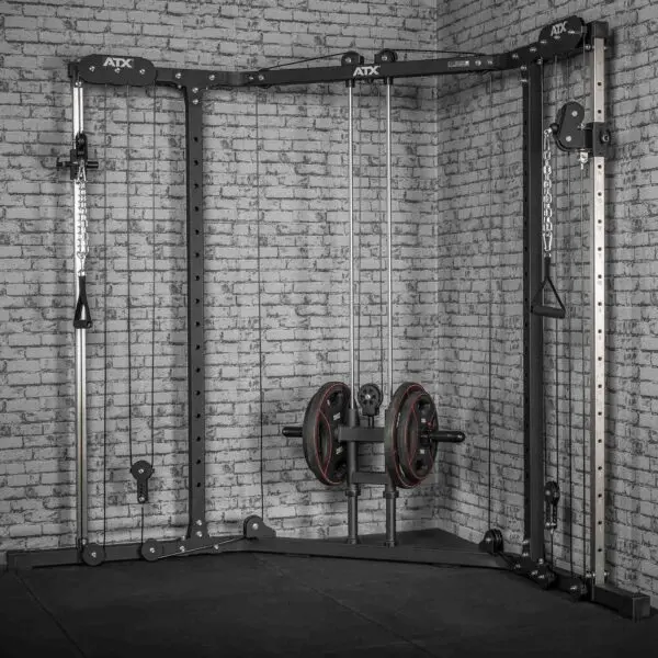 The ATX® Cable Crossover Plate Loaded, in a sleek black and silver design, stands against a light gray brick wall. With adjustable pulleys and plate-loaded weights, its ideal for versatile strength training. The floor is protected by black rubber mats.