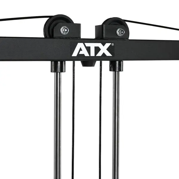 Close-up of a black ATX® Cable Crossover Weight Stack 90 kg gym machine with two pulleys and cables, displaying the ATX brand name in white. The image highlights the upper section where the cables run through the pulleys.