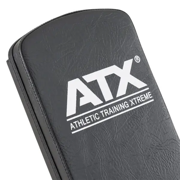 Close-up of a black padded ATX® Utility Bulls Bench featuring the white text ATX Athletic Training Xtreme on its smooth, slightly shiny surface.