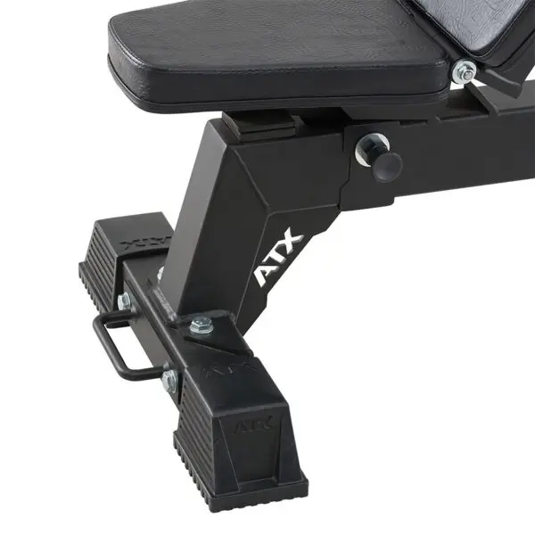Close-up of the base and adjustable mechanism of the ATX® Utility Bulls Bench, featuring a ATX logo on the side. The black workout bench has a sturdy metal frame and rubberized foot grips for stability.