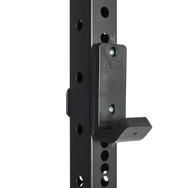 A close-up shows the ATX® logo on a black metal bracket attached to a perforated pole from the ATX® Power Rack 755 Short Distance. The bracket, designed for holding weights or gym equipment, connects to the pole with numbered holes for adjustable positioning.