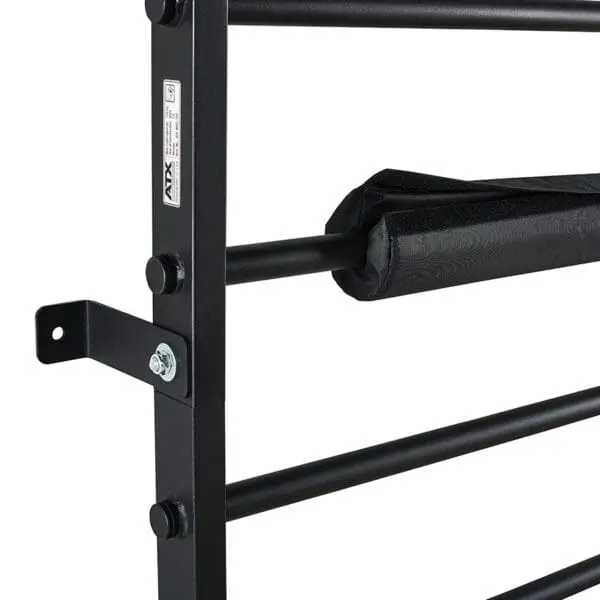 Close-up of the ATX® Wall Bar Gyms black metal structure, featuring multiple horizontal bars and a padded cover wrapped around one. The wall-mounted Swedish Bars are secured with visible bolts and a sticker on the frame.