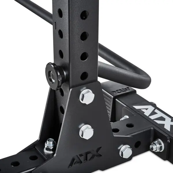 Close-up of the ATX® Squat Stands Brace, a black metal gym rack featuring adjustable holes and secured bolts. The ATX logo is visible on various parts, showcasing its sturdy construction and design.