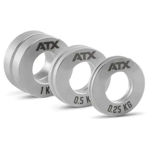 Three ATX® Olympic Fractional Plate Pairs in silver, labeled 1 kg, 0.5 kg, and 0.25 kg, are arranged in descending size with central holes for barbell placement.