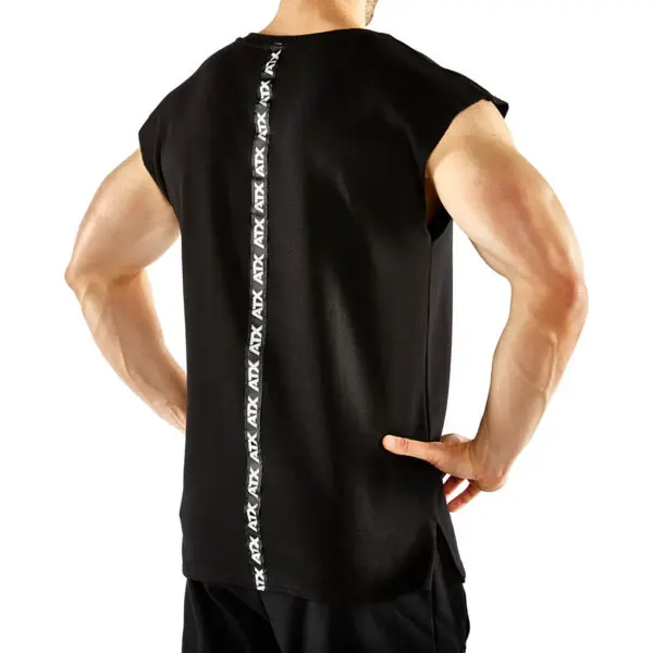 A person wears the ATX® Muscle Shirt, a sleeveless black top with a vertical ATX logo strip down the back, paired with black shorts, standing hands on hips against a plain white background.