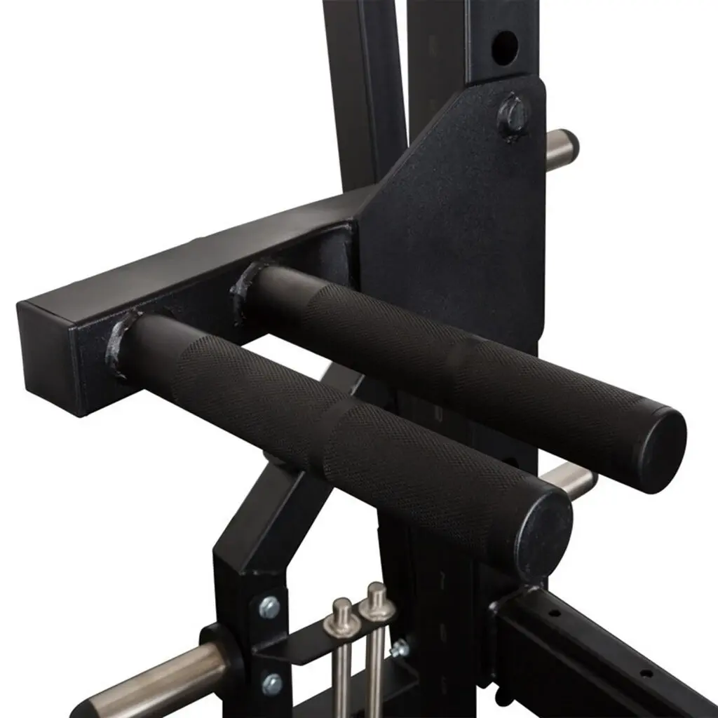 Close-up of a black gym attachment for the PRO Commercial Power Rack, featuring two cushioned parallel bars designed for tricep dips. The sturdy metal construction includes adjustable parts and handles with textured grips for stability.