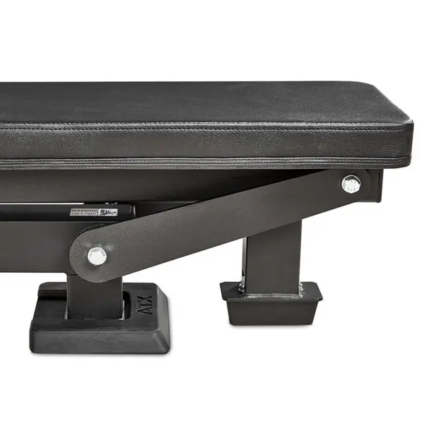 Close-up of the ATX® Trinity Tower 135 kg showing a black padded workout bench with sturdy rectangular legs and metal bolts. The bench features rubberized end caps for enhanced stability.