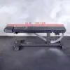 A black Ironmaster Head Extension SB adjustable gym bench sits on a black rubber floor against a gray wall, featuring a 52-inch (132.1 cm) measurement line on its frame.