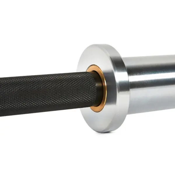 Close-up of the ATX® Ram Powerlifting Bar II IPF shows its metallic silver sleeve with a distinctive bronze-colored ring and black knurled handle, all set against a plain white background, highlighting its minimalistic and polished design.